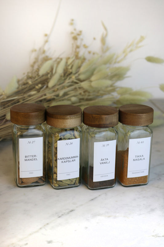Kryddburkar med stilrena vita etiketter. Trälock i akacia.