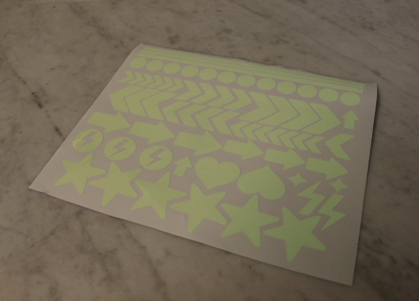 Ett ark med självlysande dekaler i halvskugga.