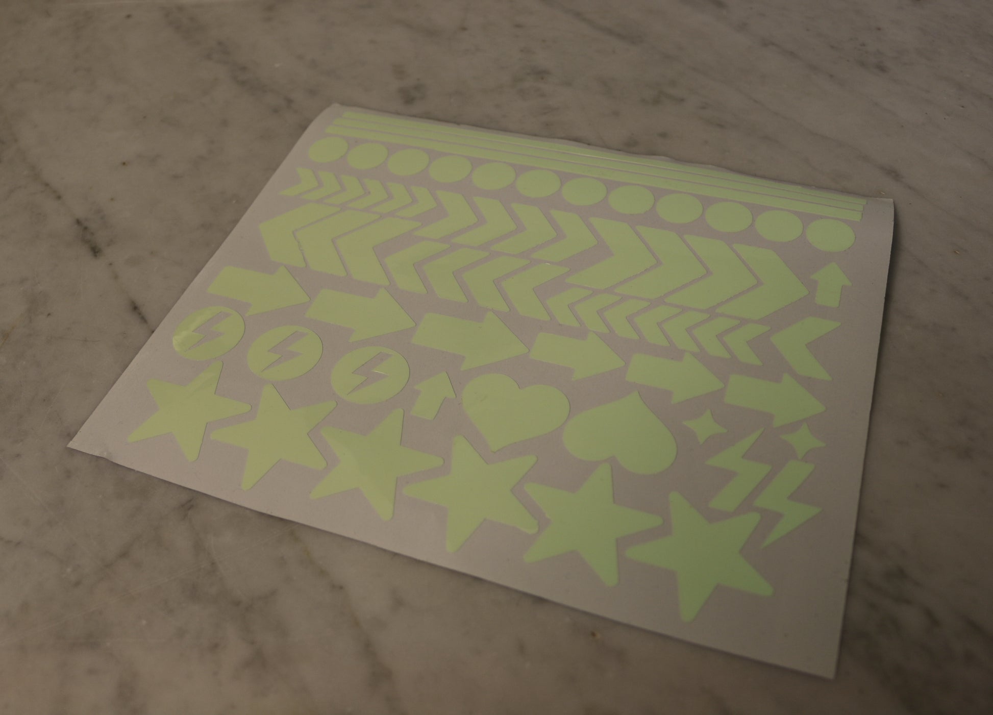 Ett ark med självlysande dekaler i halvskugga.